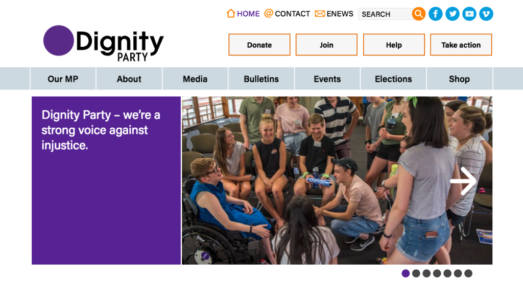Dignity Party Homepage. The tag line is visible on the left, saying 'Dignity Party- we're a strong voice against injustice'. There is a image of Kelly Vincent surrounded by a group of young people. They are laughing and smiling together. 
