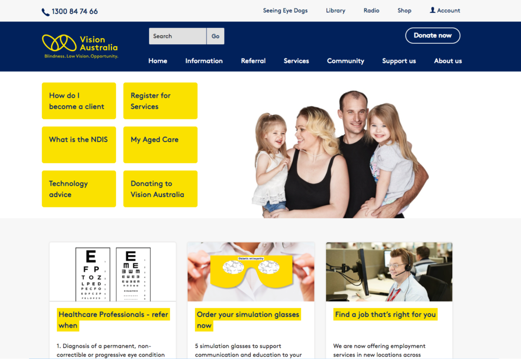 Vision Australia homepage. The menu is visible on the top left side of the page. A photo of a family, a mom and dad carrying their two young daughters can be seen on the right of the photo. 